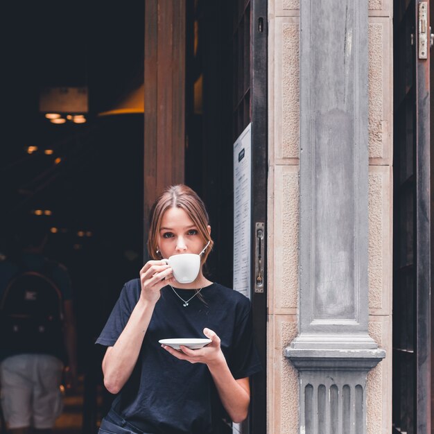 Cameriera che beve vicino al caffè