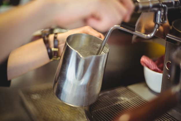 Cameriera che utilizza la macchina da caffè