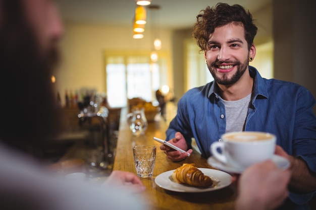 Cameriere che serve una tazza di caffè al cliente