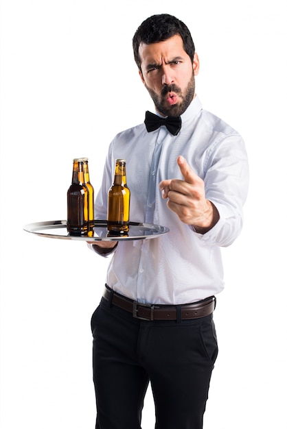 Cameriere con bottiglie di birra sul vassoio gridando