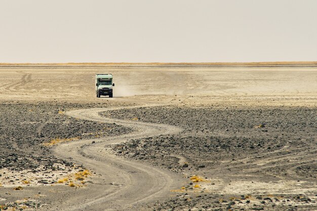 Camion che guida attraverso una strada rocciosa sinuosa che fa polvere