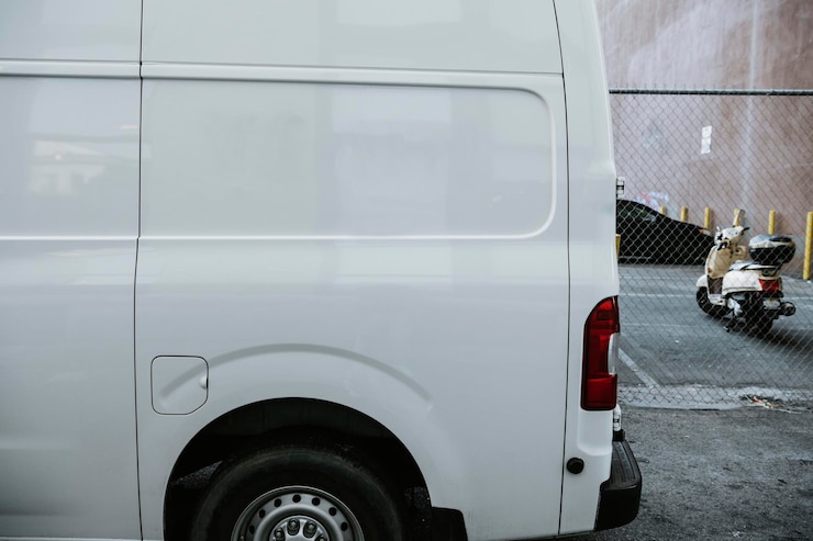 Foto gratuito camion delle consegne bianco parcheggiato in un vicolo
