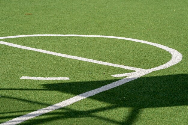 Campo da basket con terreno erboso verde, erba artificiale e linee bianche