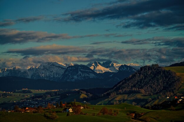 Campo di erba verde vicino alla montagna sotto il cielo nuvoloso durante il giorno