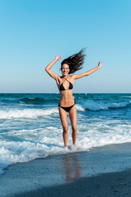 Campo lungo di bella ragazza in spiaggia