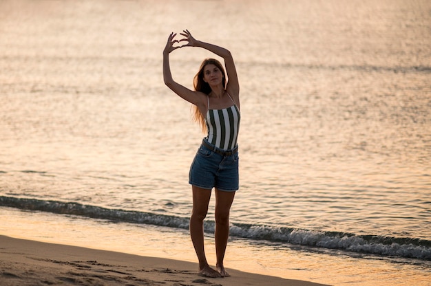 Campo lungo di bella ragazza in spiaggia