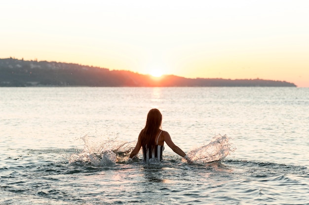 Campo lungo di bella ragazza in spiaggia