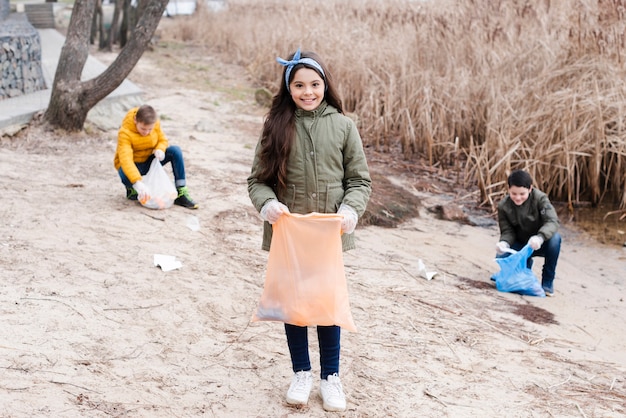 Campo lungo su bambini con sacchetti di plastica