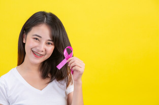 Cancro al seno, una donna in maglietta bianca con un nastro di raso rosa sul petto, un simbolo per la consapevolezza del cancro al seno