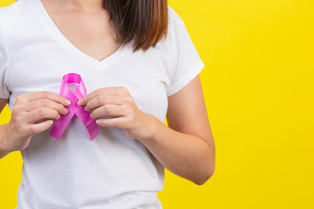 Cancro al seno, una donna in maglietta bianca con un nastro di raso rosa sul petto, un simbolo per la consapevolezza del cancro al seno