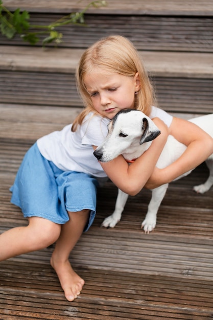 Cane che abbraccia ragazza a tiro medio