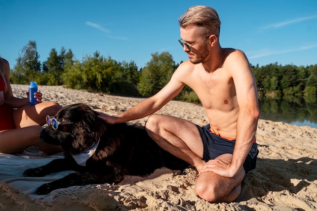 Cane da accarezzare uomo vista laterale in spiaggia