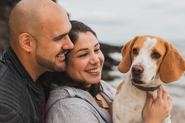 Cane e coppia in riva al mare