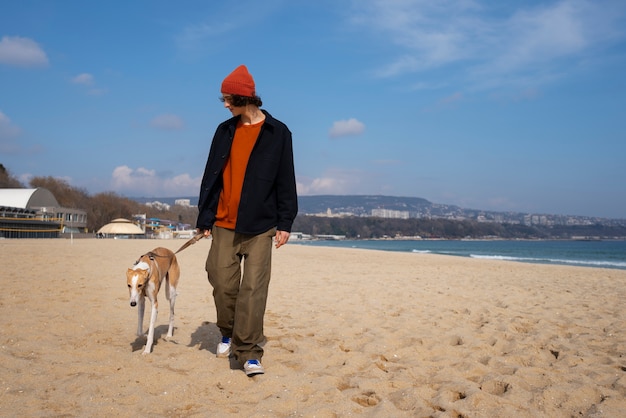 Cane levriero con proprietario maschio in spiaggia