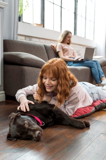 Cane petting della donna del colpo medio sul pavimento