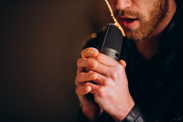 Cantante con microfono che canta in studio