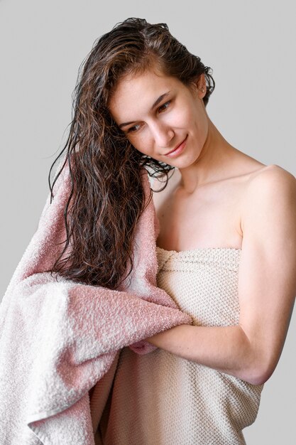 Capelli di secchezza della donna del ritratto con l'asciugamano