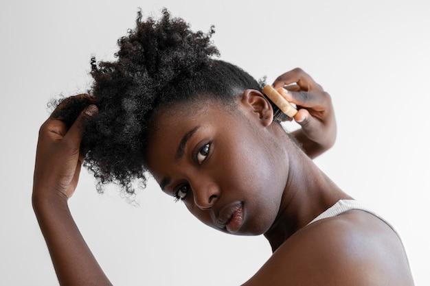 Capelli di styling della giovane donna di vista laterale