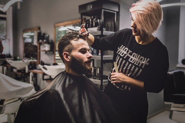 Capelli di taglio della donna dell&#39;uomo in salone