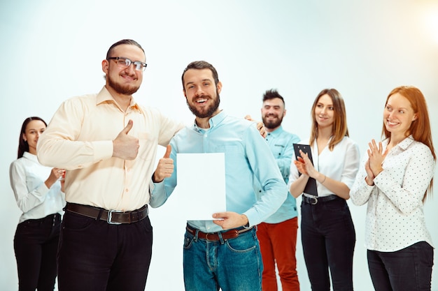 Capo che approva e si congratula con il giovane impiegato di successo