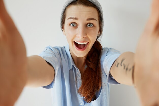 Cappello da portare della giovane ragazza della testarossa e camicia blu