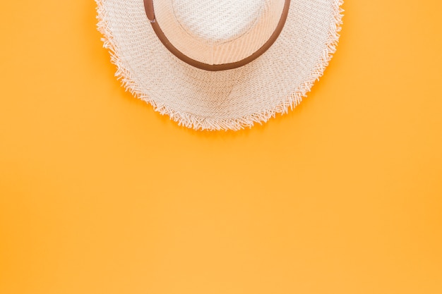 Cappello di paglia sul tavolo giallo