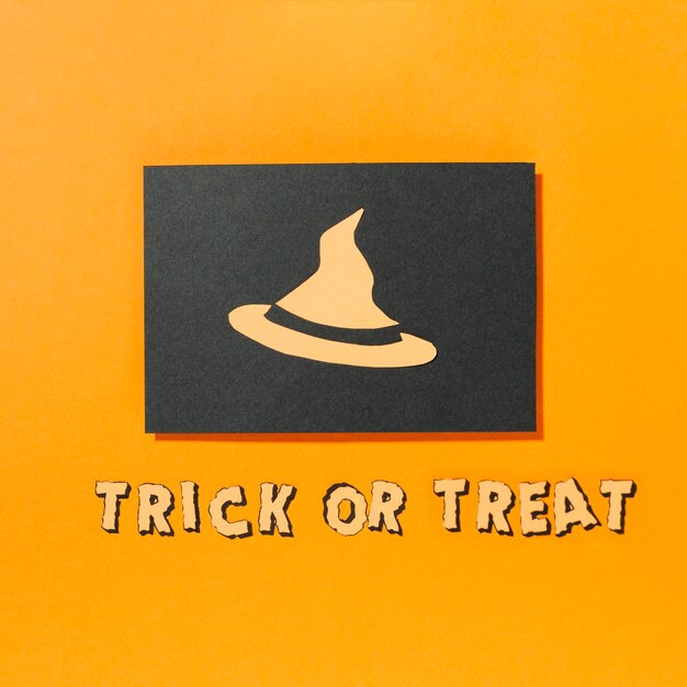 Cappello di strega su un pezzo di carta nera con iscrizione Trick or Treat