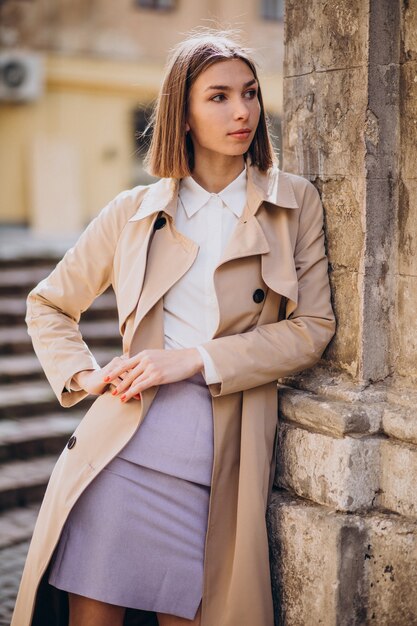 Cappotto da portare della giovane bella donna che cammina nella città