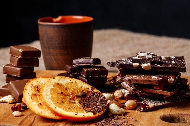 Caramelle al cioccolato arancia cannella e noci sullo scrittorio di legno.