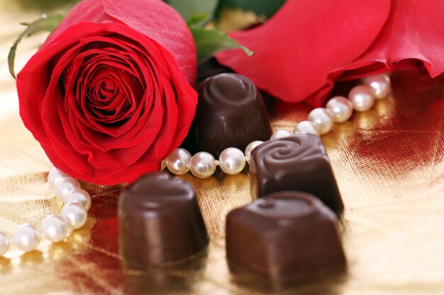 Caramelle al cioccolato e rose rosse