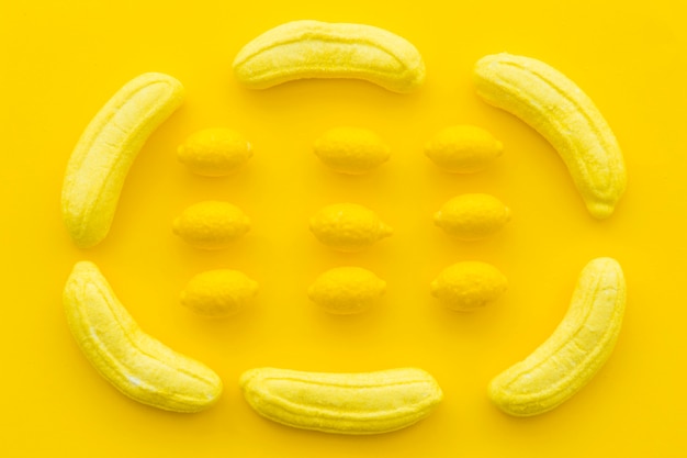 Caramelle al limone e banana su sfondo giallo