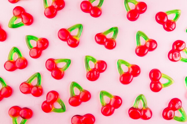 Caramelle di ciliegia di gelatina dolce su superficie rosa