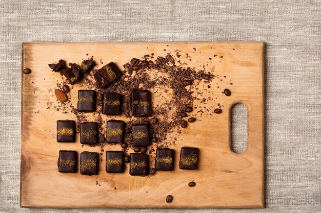 Caramelle di cioccolato sullo scrittorio di legno su tela di sacco