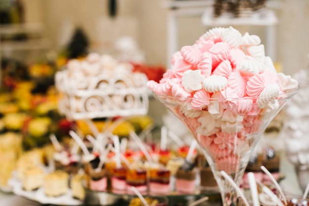 Caramelle gommosa e molle dolci in una tazza con fondo vago