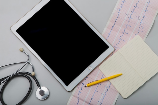 Cardiogramma e tablet con blocco note