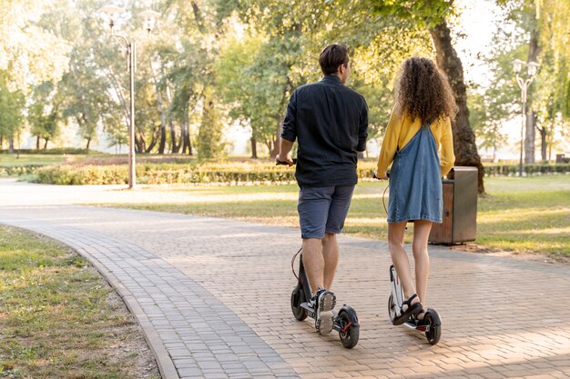 Carino giovane coppia equitazione scooter all'aperto