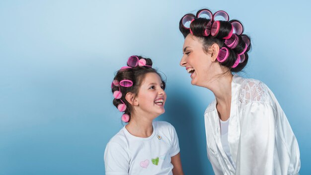 Carino madre e figlia in bigodini ridere