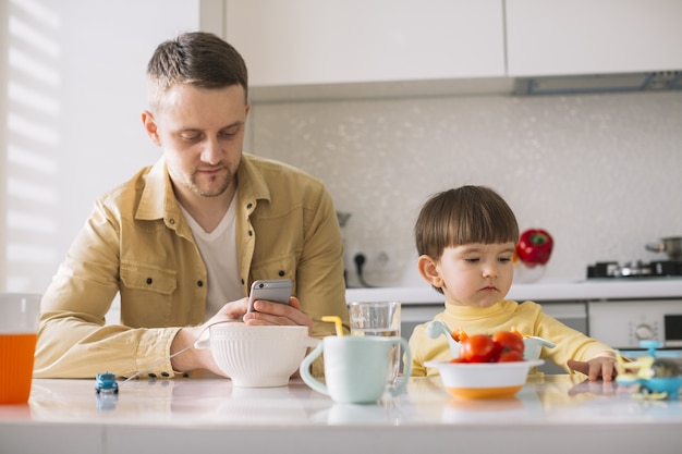 Carino piccolo bambino e suo padre vista frontale