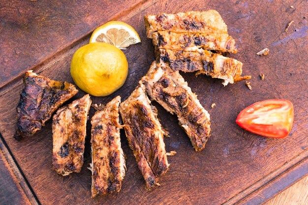 Carne alla griglia e pomodoro a fette di limone sul tavolo