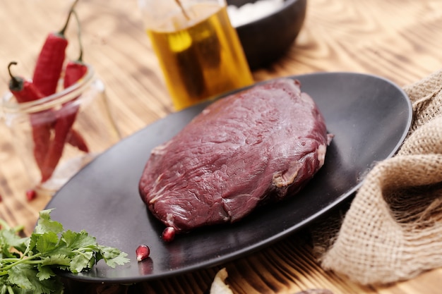 Carne cruda con ingredienti per cucinare il pasto