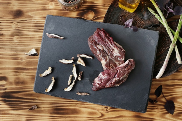 Carne cruda con ingredienti per cucinare il pasto