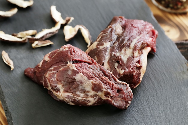 Carne cruda con ingredienti per cucinare il pasto