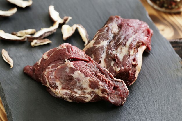 Carne cruda con ingredienti per cucinare il pasto