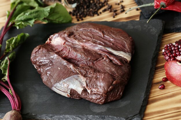 Carne cruda con ingredienti per cucinare il pasto