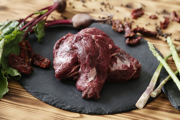 Carne cruda con ingredienti per cucinare il pasto