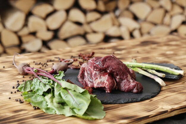 Carne cruda con ingredienti per cucinare il pasto