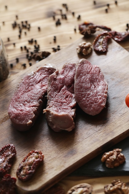 Carne cruda con ingredienti per cucinare il pasto