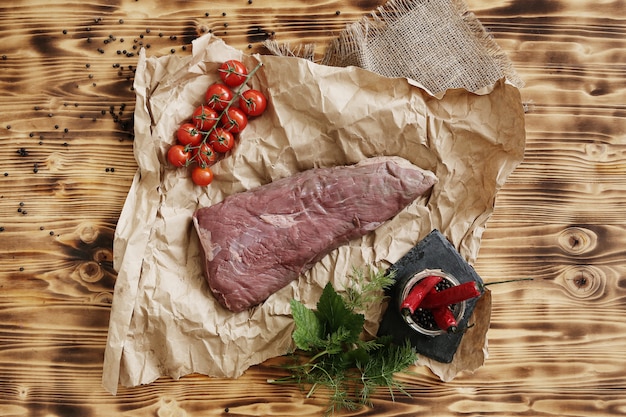 Carne cruda con ingredienti per cucinare il pasto