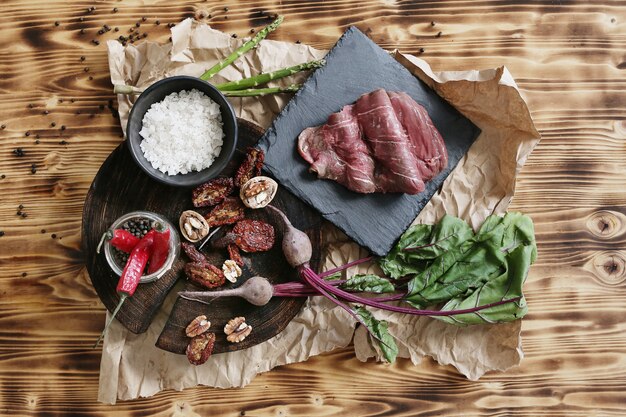 Carne cruda con ingredienti per cucinare il pasto