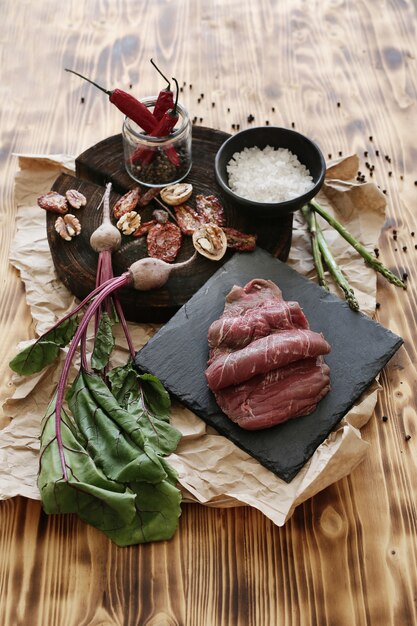 Carne cruda con ingredienti per cucinare il pasto